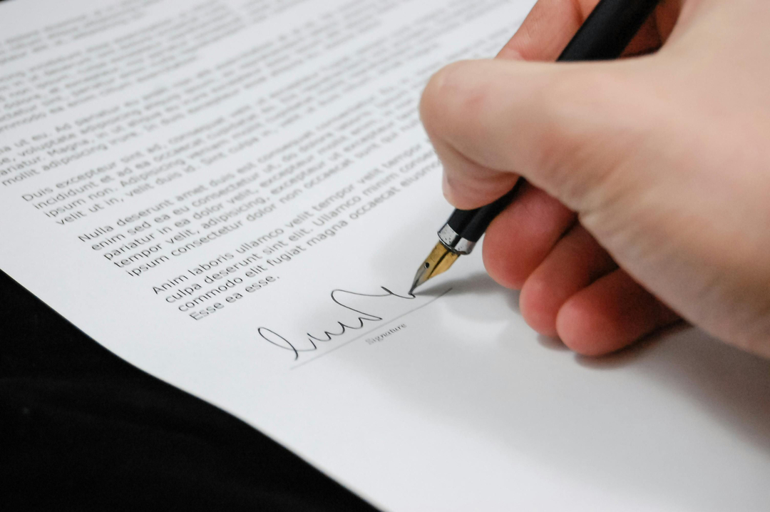 Signature d'un contrat juridique sur un bureau professionnel – Expertise en droit des affaires et accompagnement stratégique par le cabinet Asmar & Assayag.