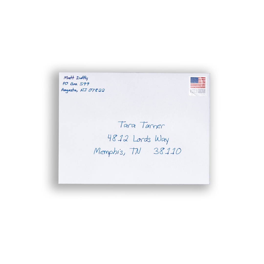 A white A7 envelope with blue handwriting on it and a postage stamp. 