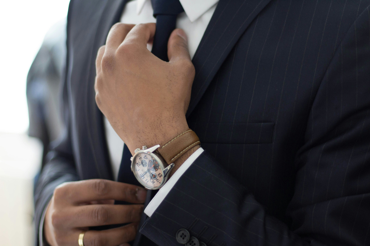 Professionnel en costume ajustant sa cravate – Expertise en droit social et gestion des relations de travail chez Asmar & Assayag.