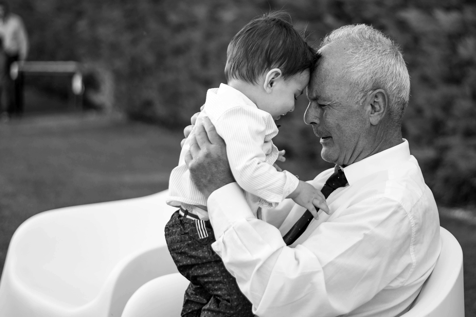 Opa auf Bank freut sich mit Enkel über Vorsorge Keuchhusten Impfschutz