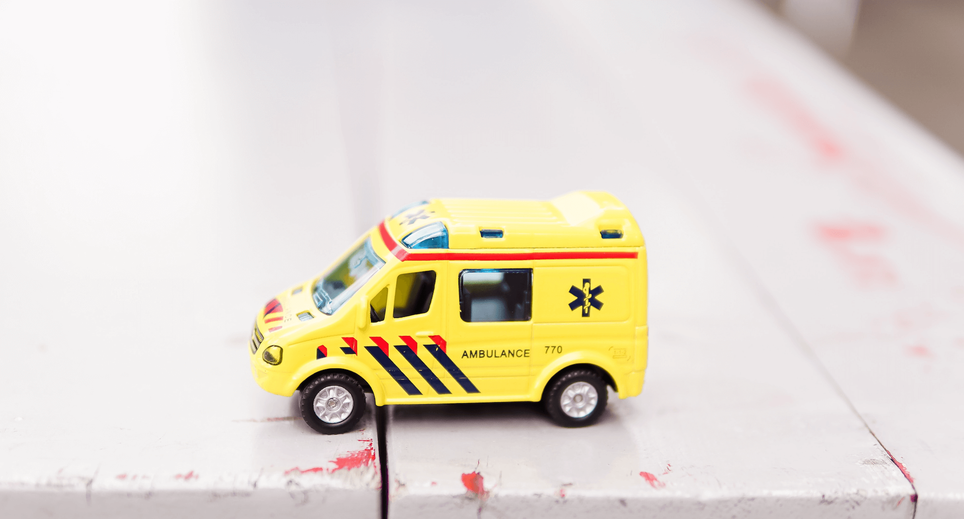 Spiezeug-Krankenwagen auf einem Holztisch.