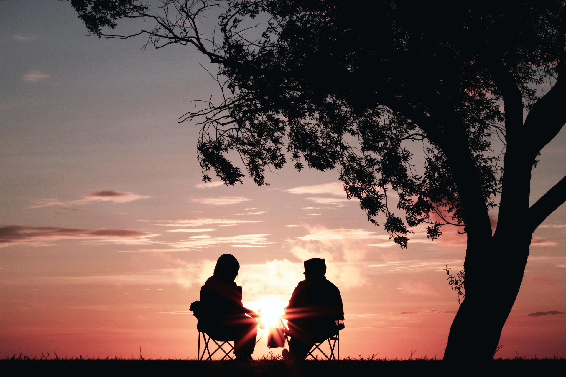 zwei Personen genießen den Sonnenuntergang.