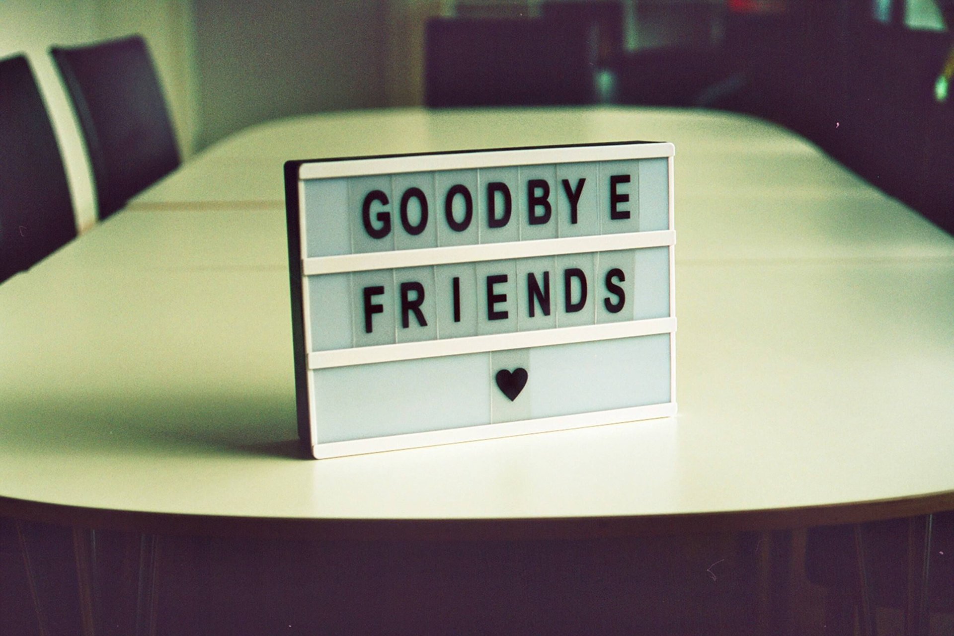 Schild auf einem Tisch mit Aufschrift "Goodbye Friends"