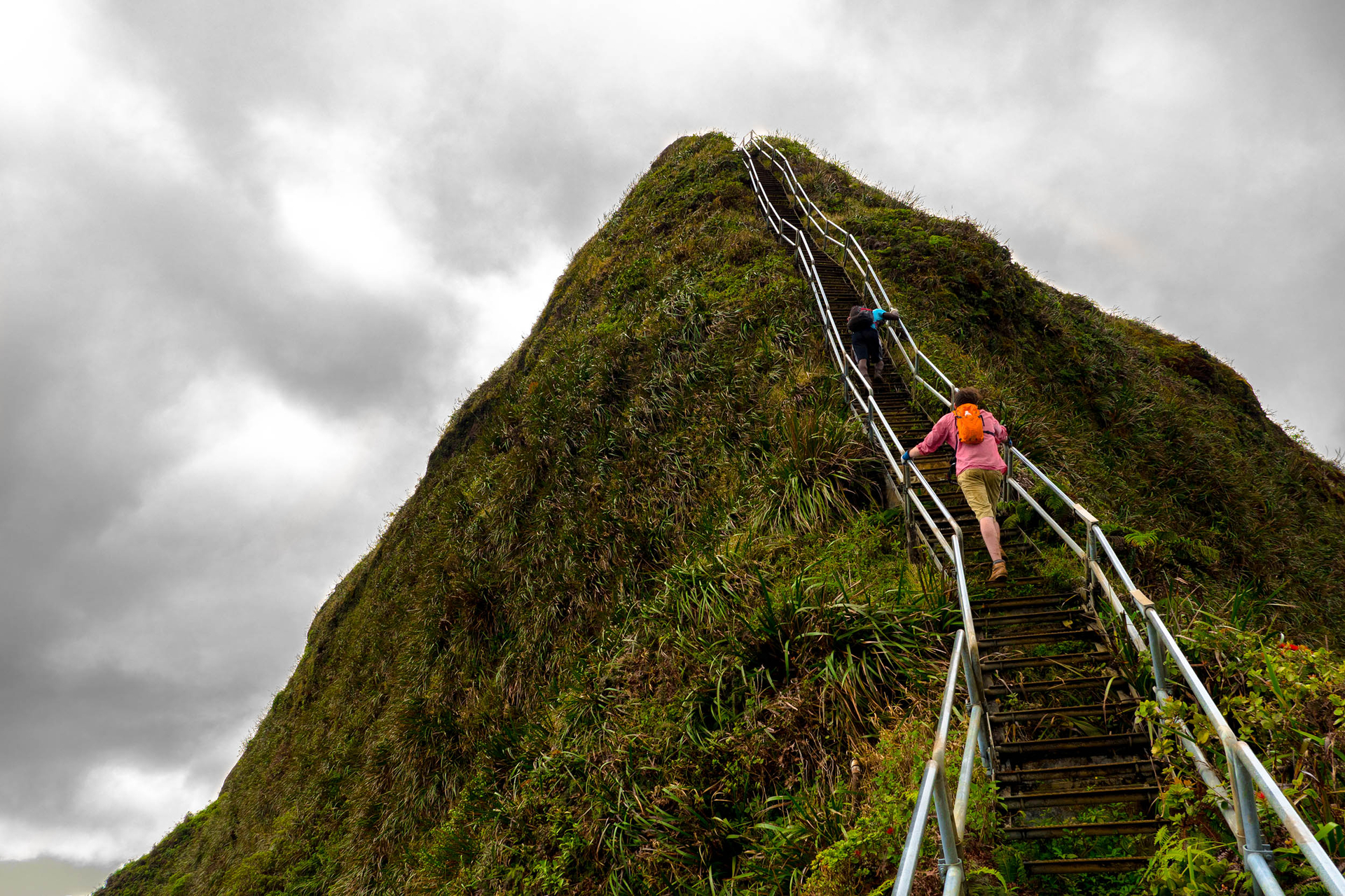 How to scale your business. A person walking up a great flight of stairs up a mountain