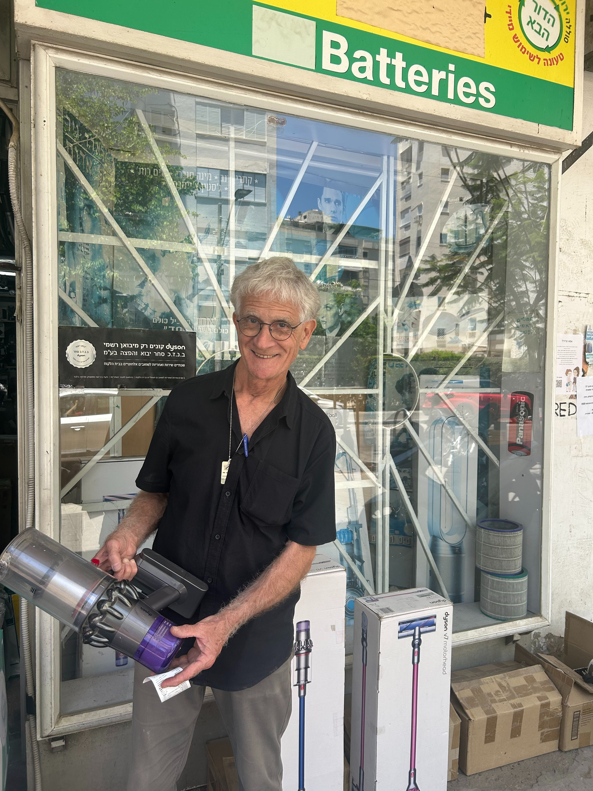 טכנאי מומחה מחזיק שואב אבק דייסון במעבדה מורשית בתל אביב