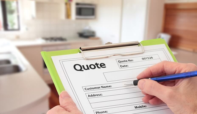 Contractor writing a quote form in a client’s kitchen